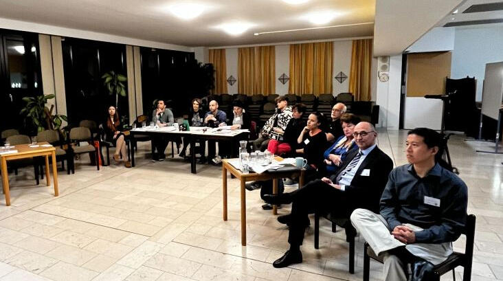 people sitting at tables attending a meeting