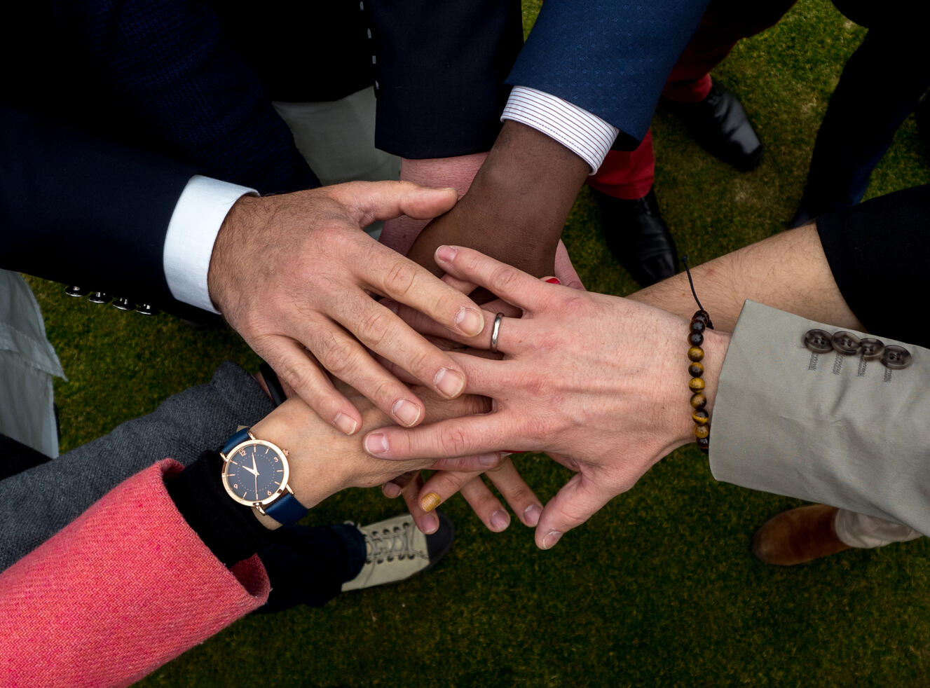 an image showing hands from different people stacking on top of each other